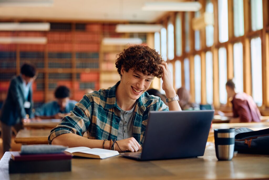 Happy,Student,Using,Laptop,While,Learning,During,A,Class,At